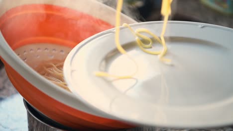 close up of a person serving spaghetti on a plate