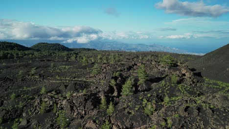 flying-over-lunar-landscape-with-forest-ecosystem,-near-volcano