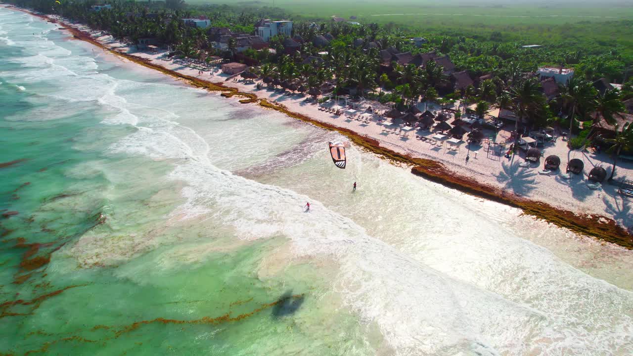 vista aérea de drones de niños volando cometa de playa de paracaídas en una playa caribeña tropical