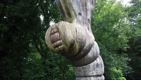 strange wooden carved alien caterpillar at the entrance of welsh woodland forest trail