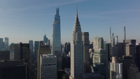 Forwards-ascending-fly-above-buildings-in-town.-Heading-to-iconic-Chrysler-buildings-with-crown-and-spire.-Manhattan,-New-York-City,-USA