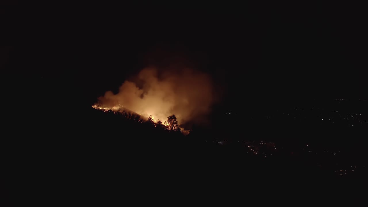 어두운 하늘에서 연기가 나는 산불 실루엣