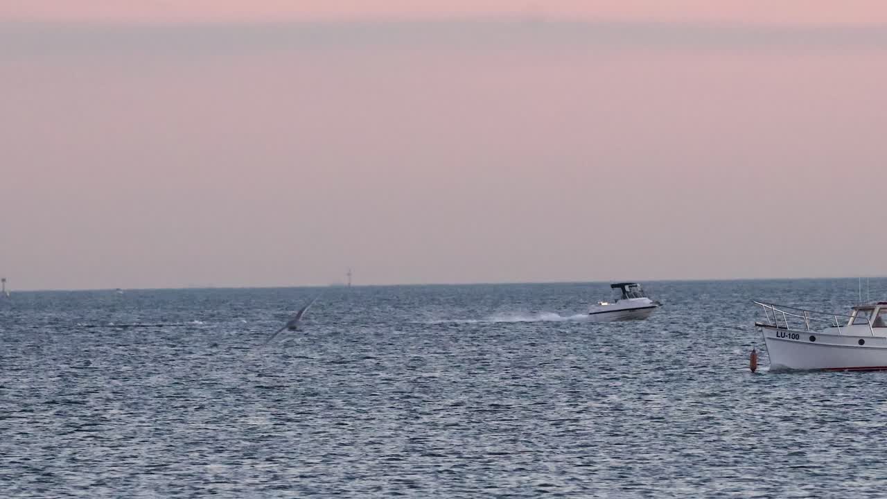 해가 지면 배가 바다를 가로질러 이동합니다.