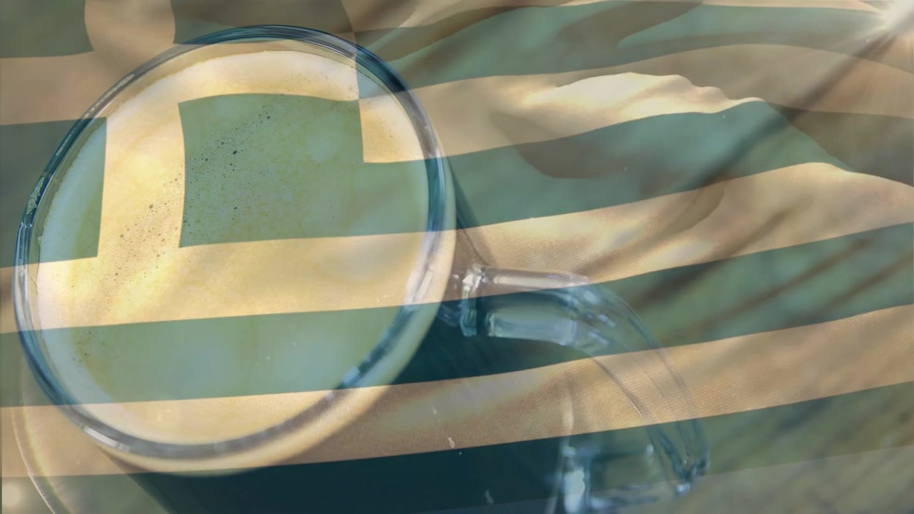 Striped flag overlay drifting and rippling, revealing cup rim and pale foam on weathered wood