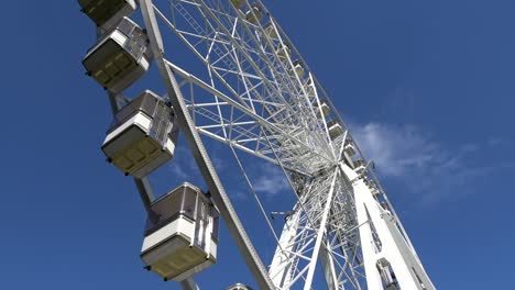 4k. una gran rueda está de pie y comienza a girar. parque de atracciones