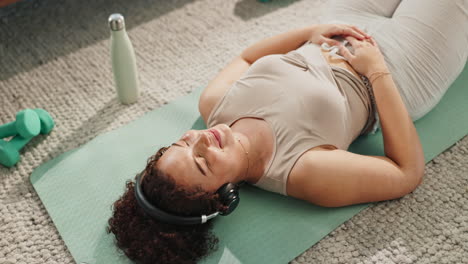 woman relaxing on yoga mat with headphones