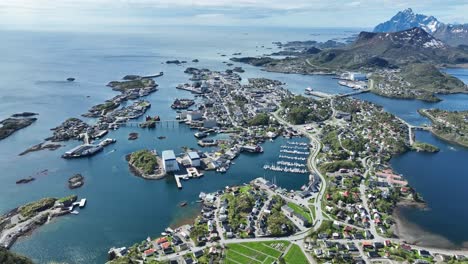 drone slowly ascends showing svolvaer in lofoten with sea, boats, harbor, cars and spring scenery