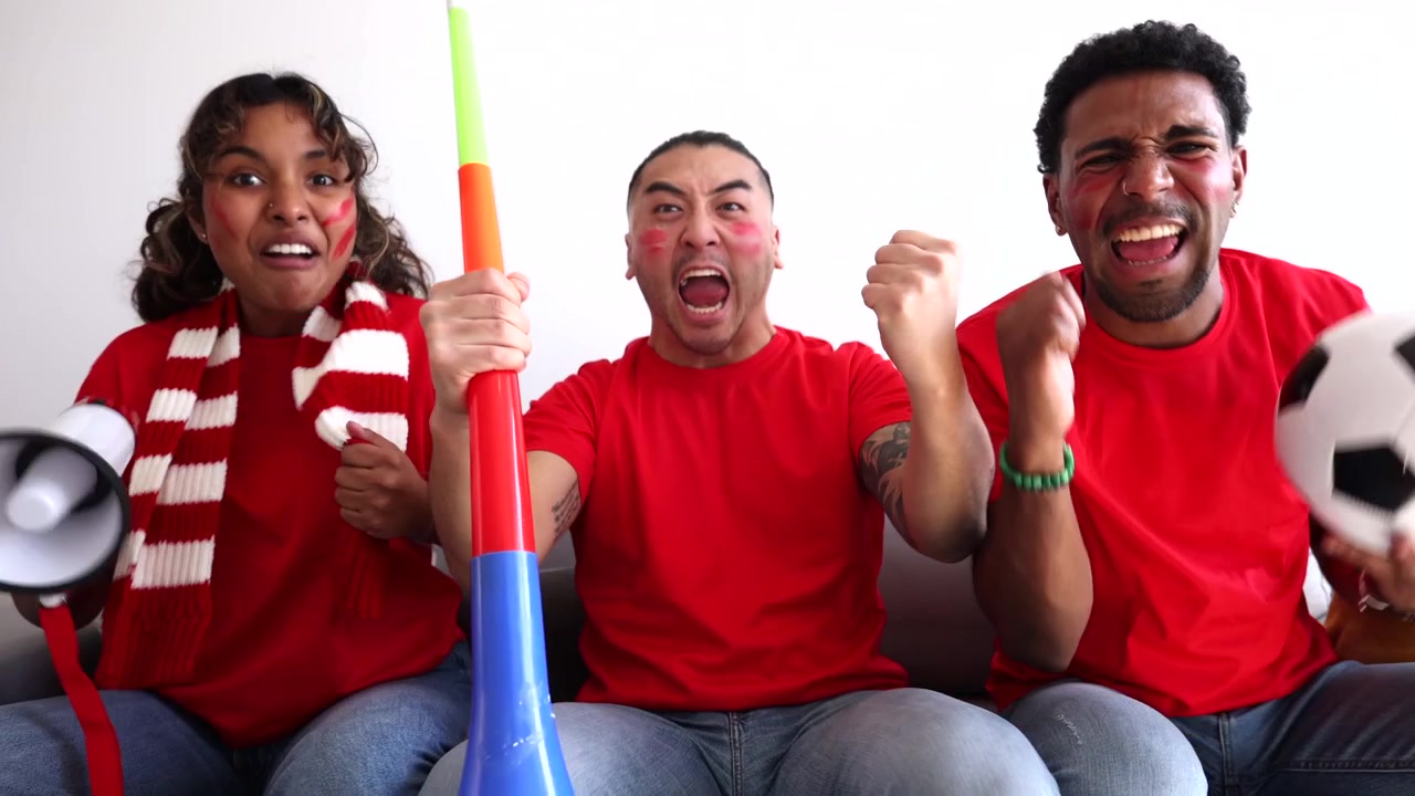 Grupo diverso de aficionados al fútbol animando a su equipo