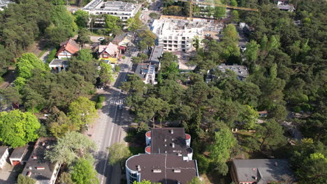 aerial view of cars driving in the street of jurata with green trees and house in poland