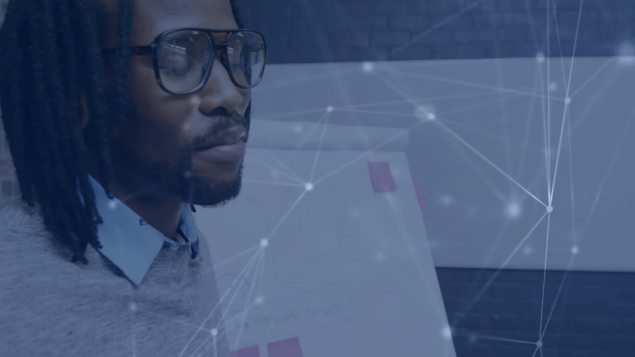 Animation of network of connections over biracial businessman talking in office