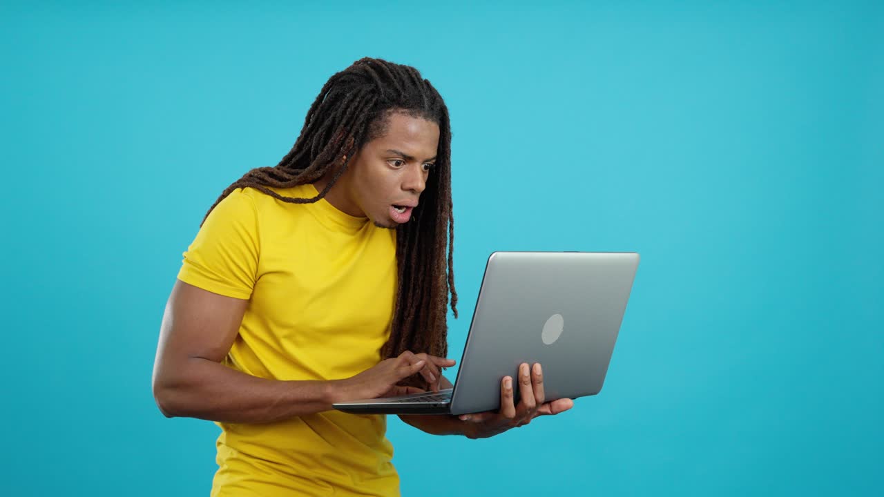 Mann mit Laptop, der Überraschung ausdrückt