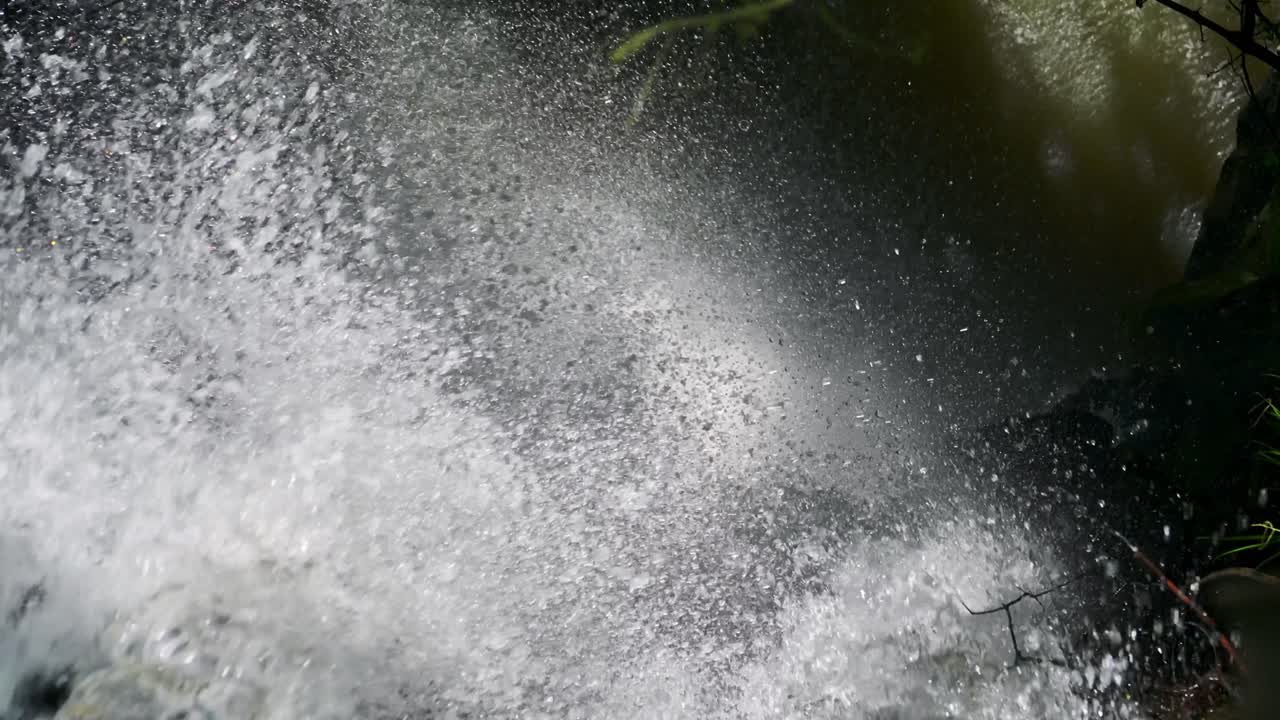 vista en cámara lenta de la cascada cayendo de un acantilado, estrellándose agua detallada en el hermoso paisaje argentino desde la vista de los pájaros en el agua brillante goteando desde el borde de una cascada empinada en iguacú, américa del sur