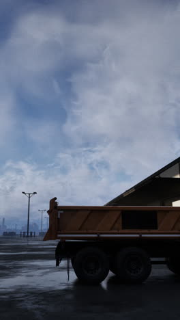 dump truck parked in an empty parking lot on a cloudy day