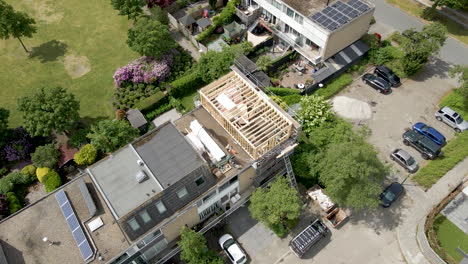 aerial overview of wooden frame of roof structure under construction in a suburban neighborhood