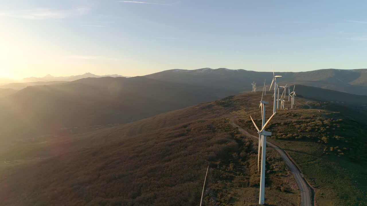 Windmills at the top of a mountain in the sunset aerial shot