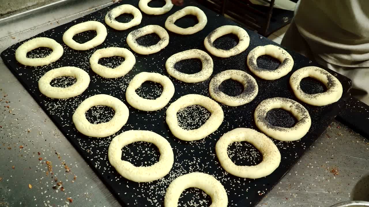 el panadero salpica bagels con semillas de sésamo y amapola