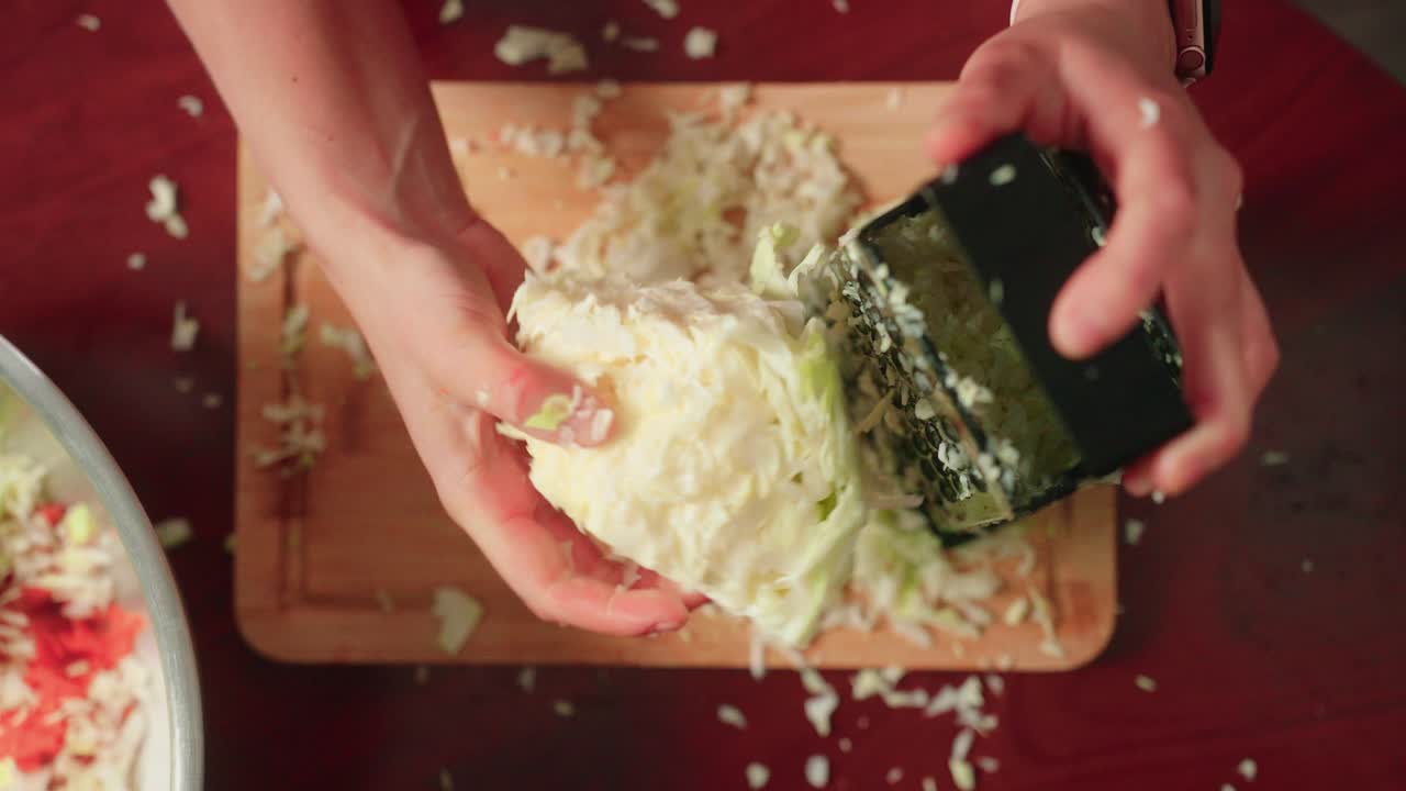 Shredding cabbage by hand with cheese grater