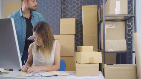 entrepreneur woman packing e-commerce product order and sticking warning note.