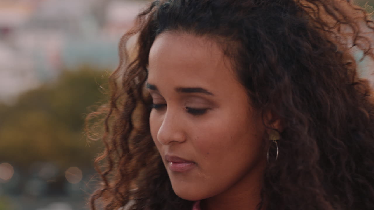 retrato hermosa joven mujer hispana bebiendo alcohol disfrutando de una bebida refrescante fría relajándose en el techo con el viento soplando el cabello