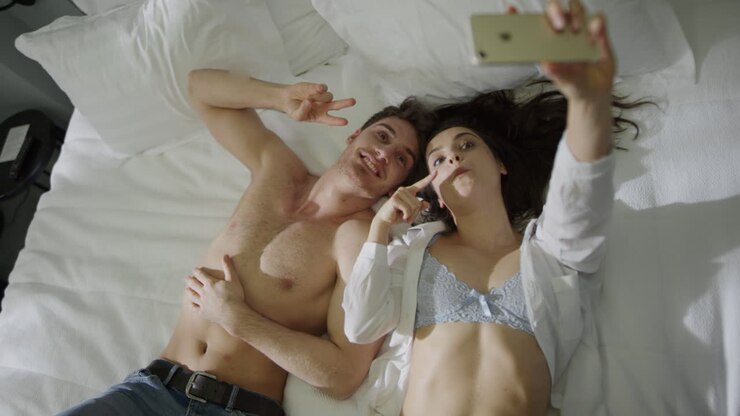 Sexy couple lying on hotel bed