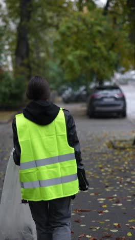 woman cleaning up trash on city street