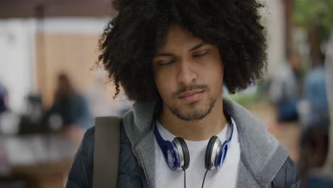 close up portrait of young mixed race man looking serious at camera pensive male student commuter in urban background