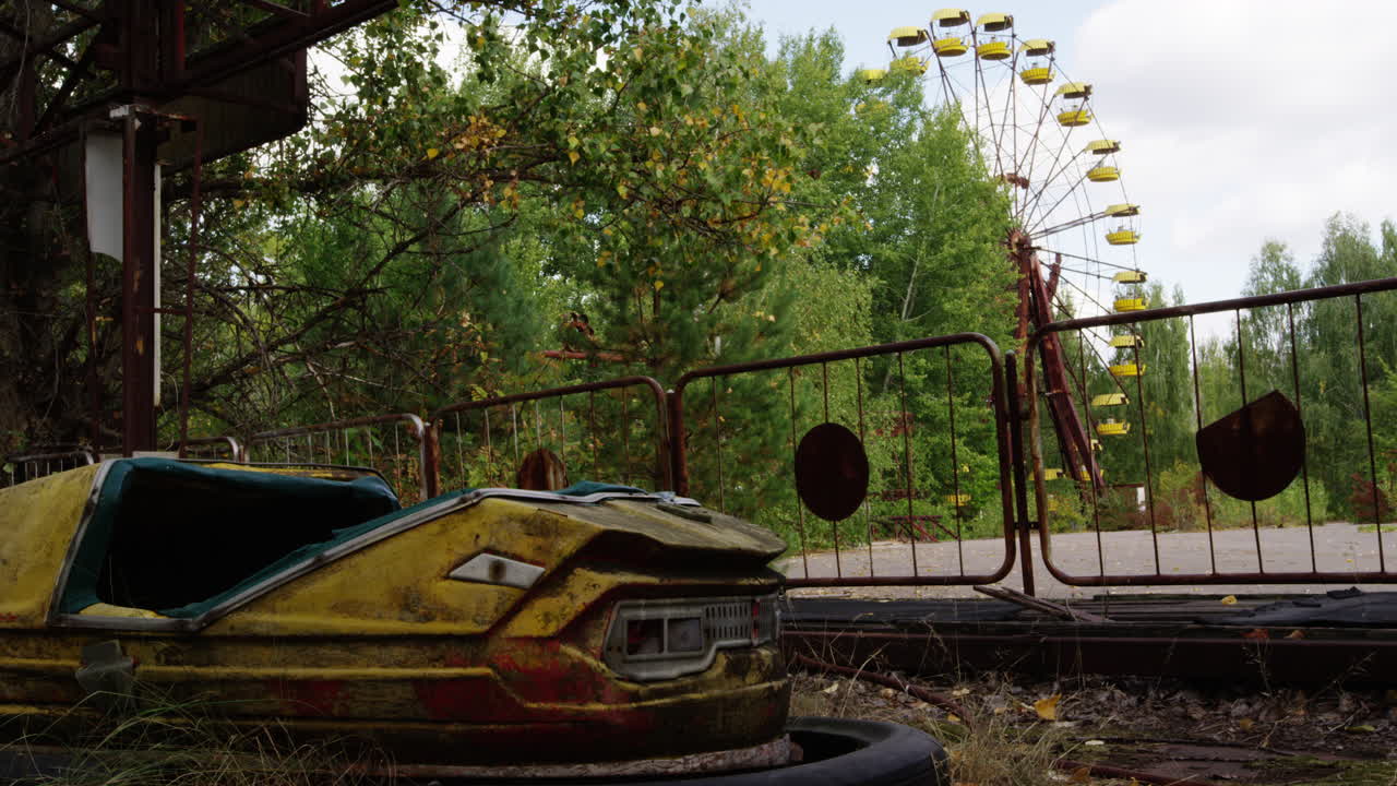 желтый бамперный автомобиль в увеличенном масштабе с колесом обозрения на заднем плане, припять
