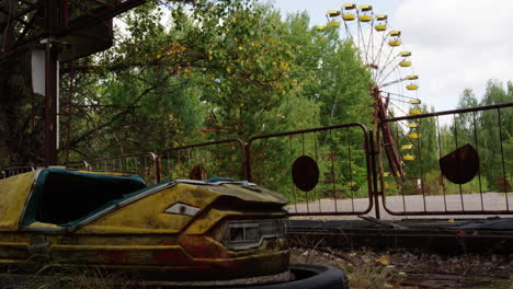 yellow bumper car in zoom in view with ferris wheel in background, pripyat