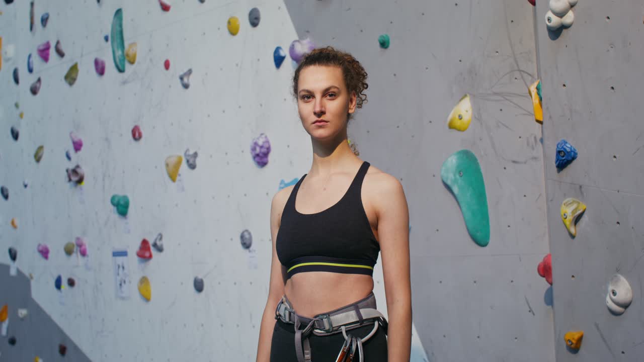 mujer escaladora en un gimnasio de escalada en roca cubierto