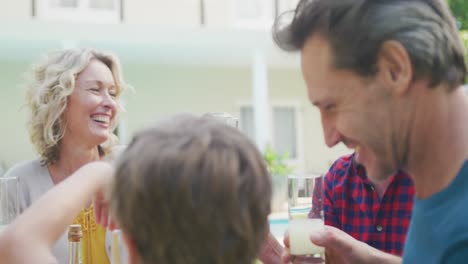 Happy-caucasian-family-having-dinner-and-talking-in-garden