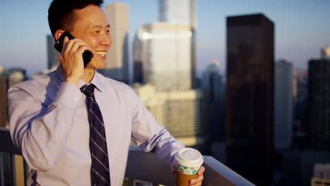 chinese male executive using mobile technology on rooftop