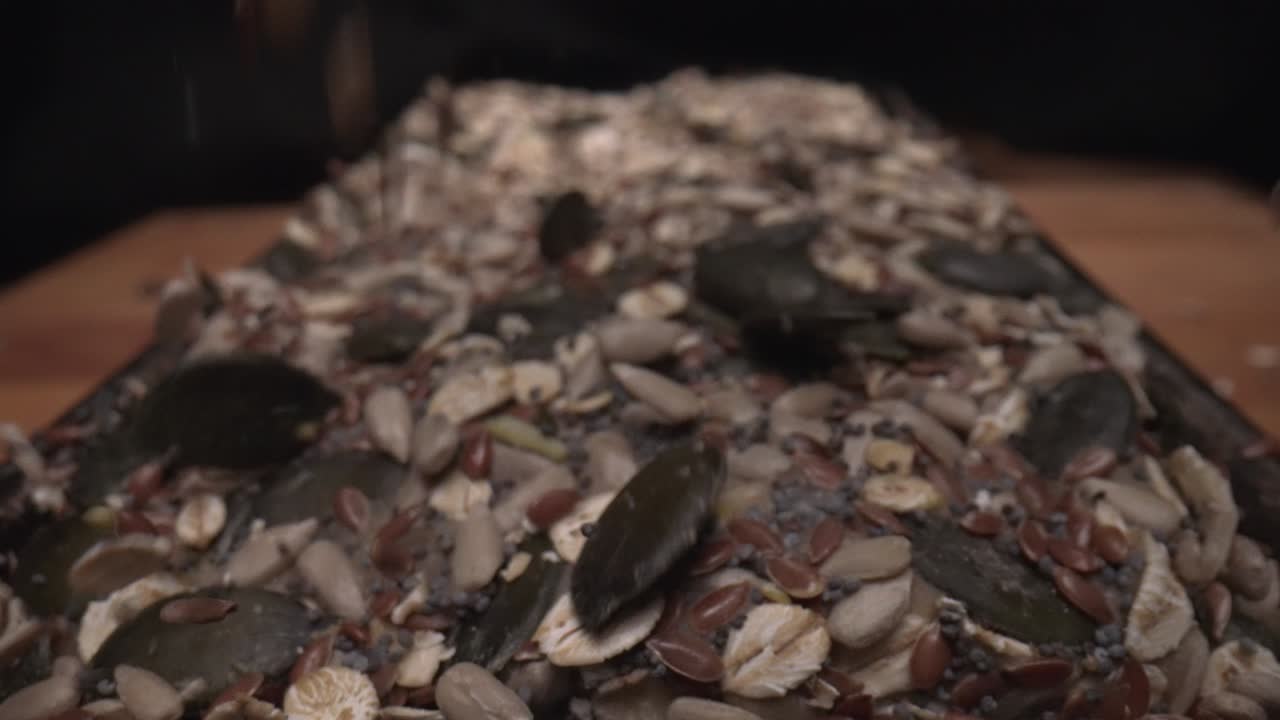 toma macro en cámara lenta de semillas que se caen encima del pan recién horneado