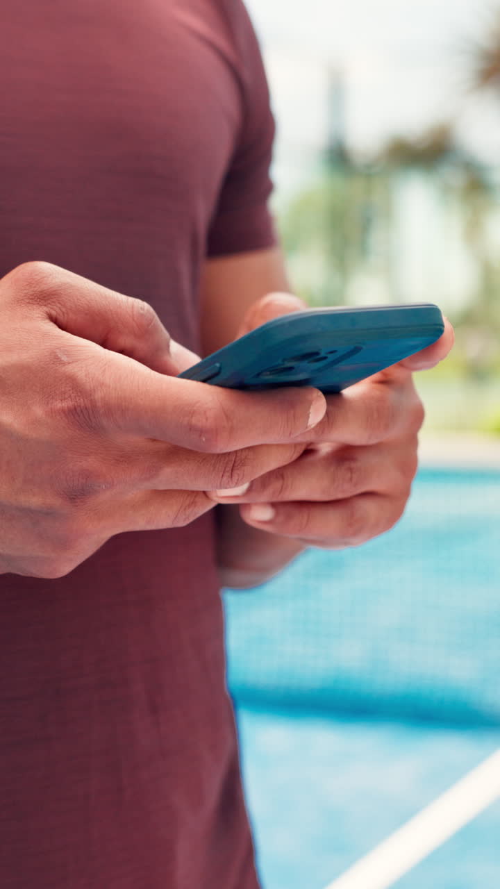 Close-up of Person's Hands Typing on a Smartphone by a Pool