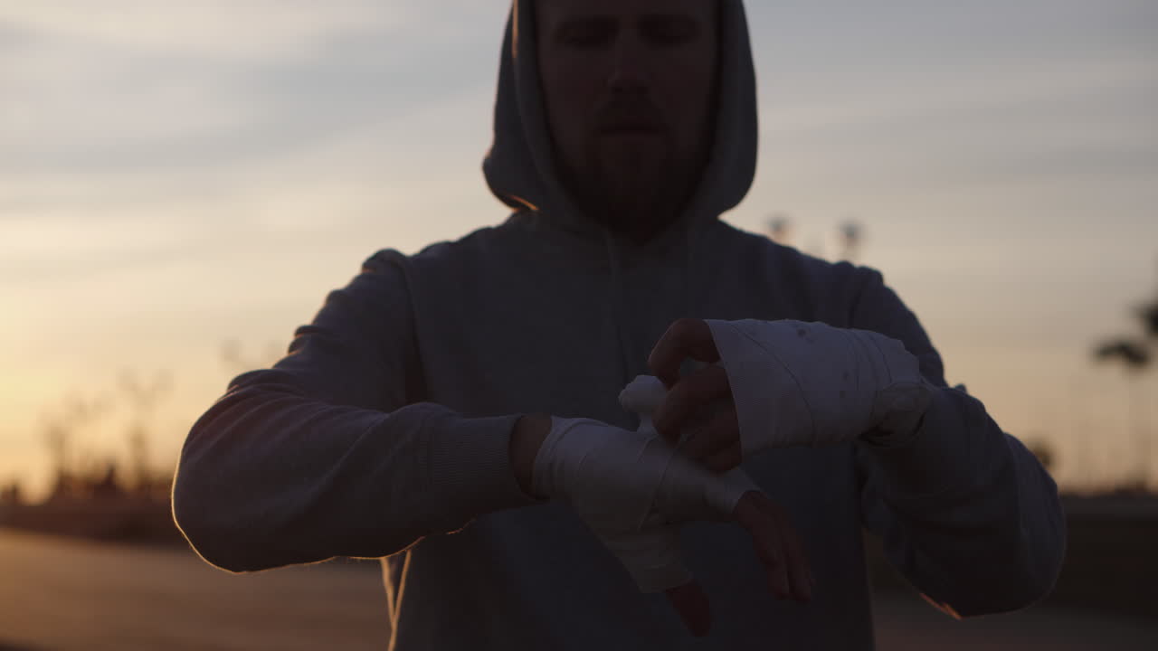 hombre preparándose para el entrenamiento de boxeo al atardecer