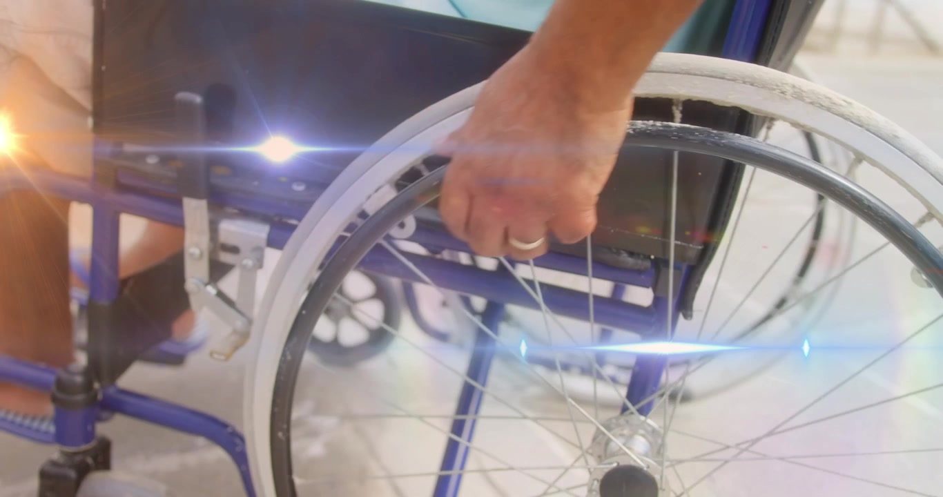 Spot of light against mid section of disabled man walking on wheelchair