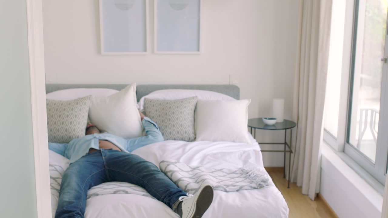 침실, 지쳤고 피곤한 남자가 누워 있습니다.