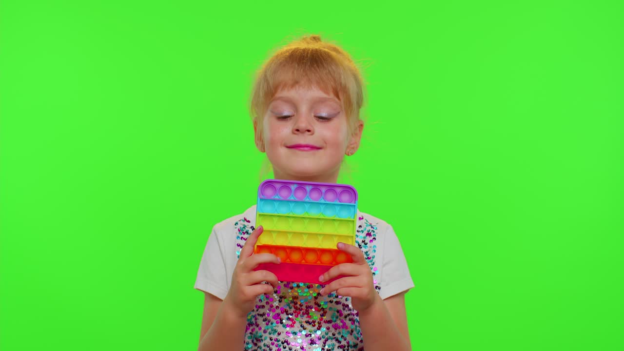 niña jugando a empujar pop it burbuja inquietud estrés ansiedad alivio exprimir juguetes sensoriales