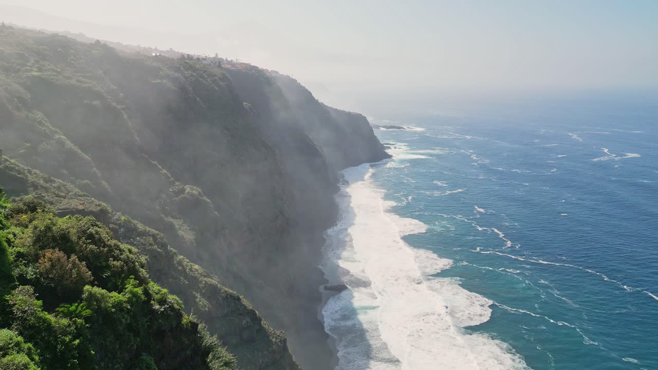 vista aérea de un acantilado gigante con las poderosas olas del océano rompiendo en un hermoso día soleado