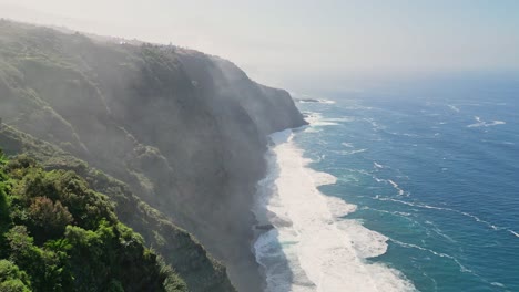 Vista-Aérea-De-Un-Acantilado-Gigante-Con-Las-Poderosas-Olas-Del-Océano-Rompiendo-En-Un-Hermoso-Día-Soleado