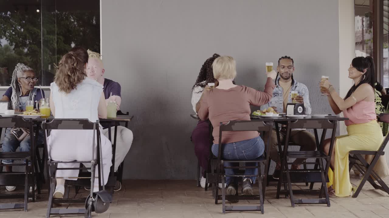 Diverse Group of Friends Toasting and Socializing at an Outdoor Restaurant