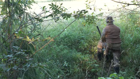 cazador vestido con camuflaje escondido en el bosque, cámara lenta cinematográfica con poca profundidad de campo