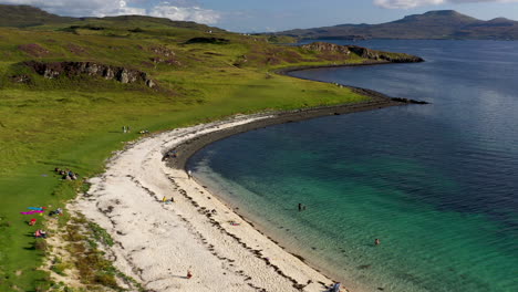 cinematic drone shot of coral beach in claigan with white sandy beaches and tropical blue water, just north of dunvegan scotland