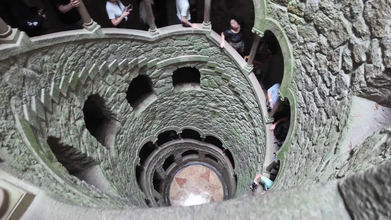Tourists explore the spiral staircase of Quinta da Regaleira in Sintra, Portugal