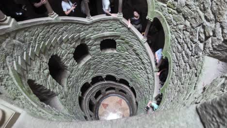 tourists explore the spiral staircase of quinta da regaleira in sintra, portugal