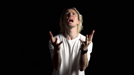 a blond young man frustratedly screaming in angriness