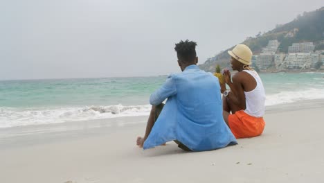 Rückansicht-Eines-Afroamerikanischen-Paares,-Das-Ananassaft-Am-Strand-4k-Trinkt