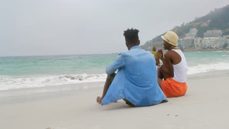 rear view of african american couple drinking pineapple juice on the beach 4k