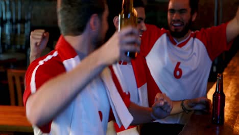 Friends-cheering-while-having-beer-at-bar-counter