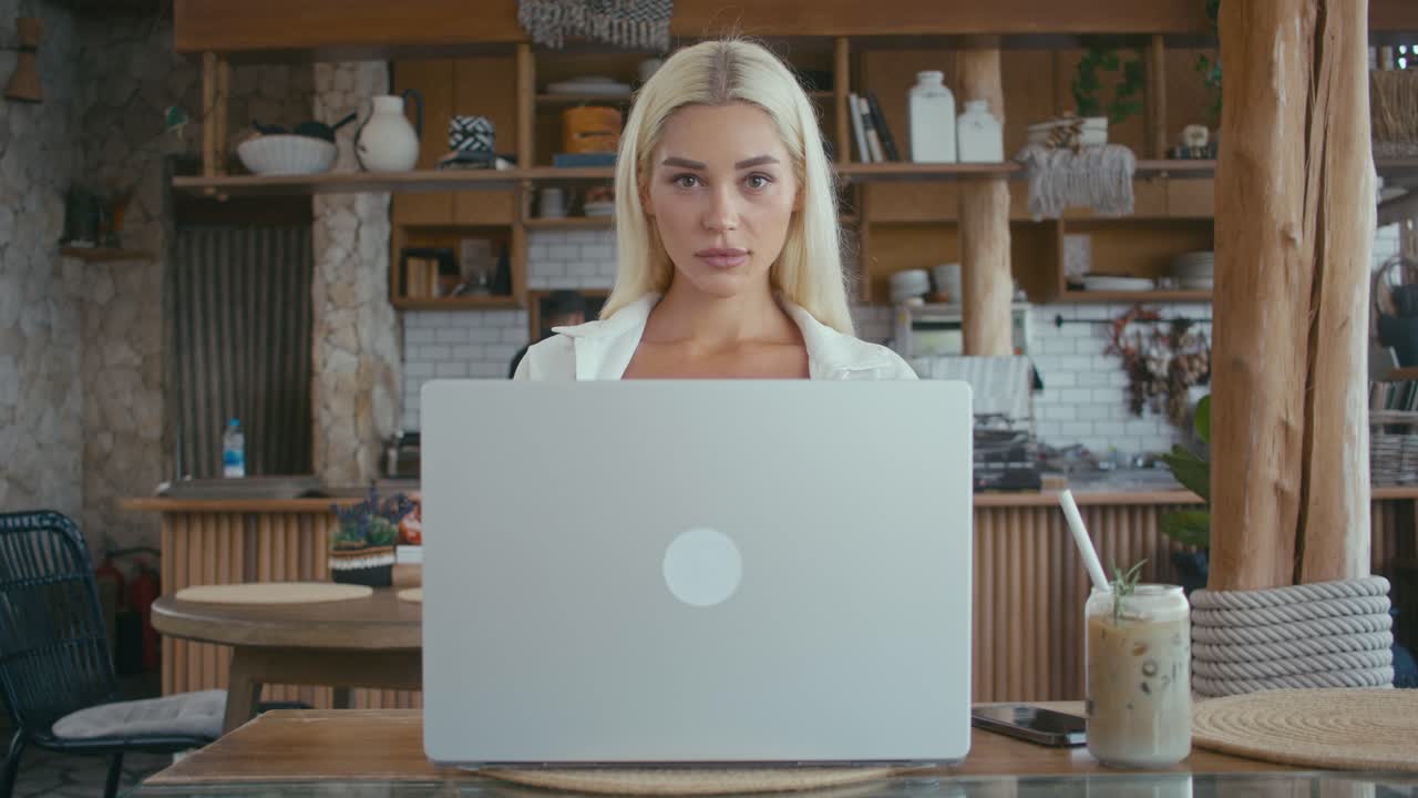 Donna che lavora al computer portatile in un caffè
