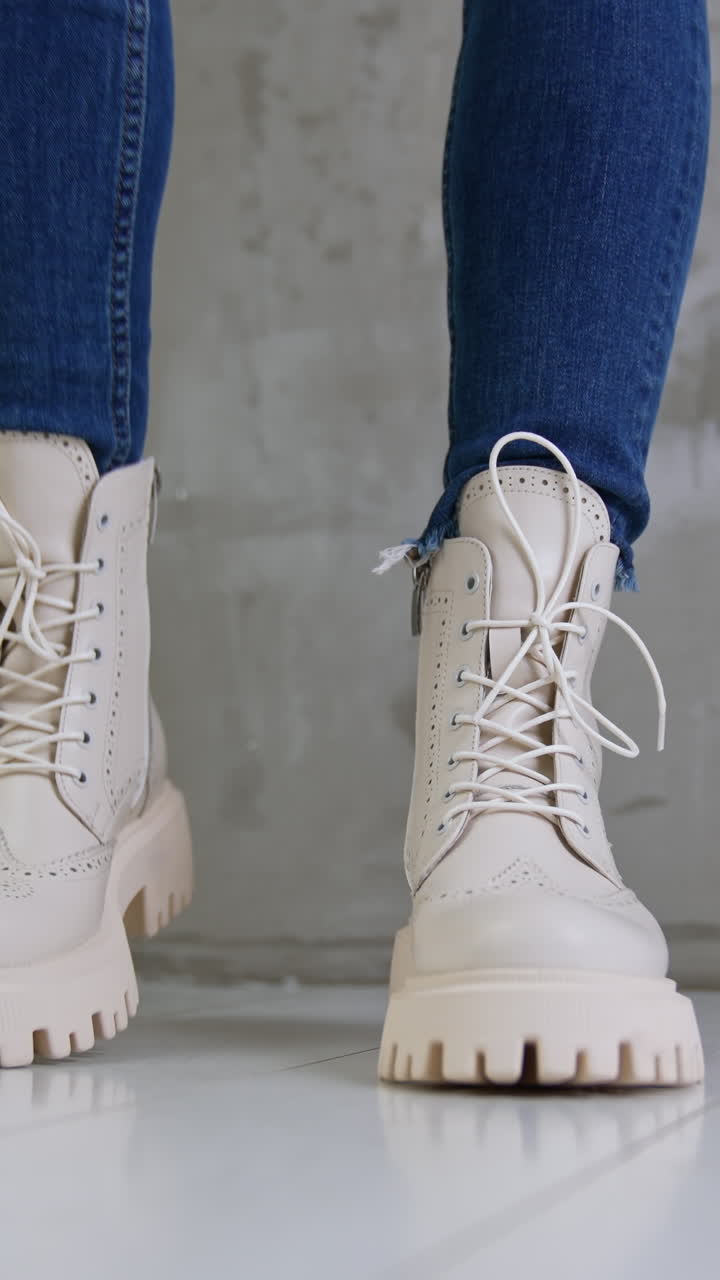 Woman's cream colored boots with jeans